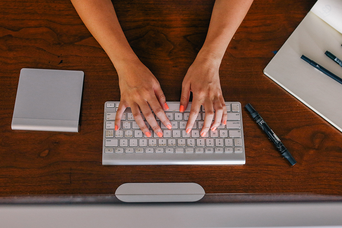 hands typing on a computer keyboard