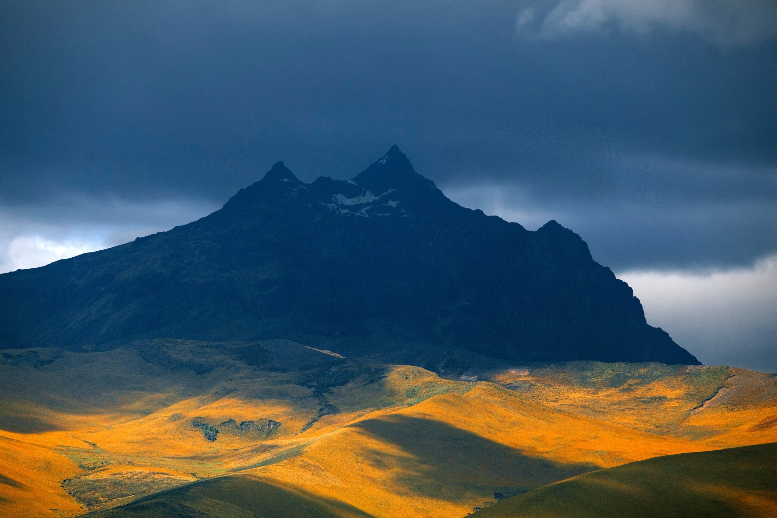 mountains in the shadow of dark rain clouds